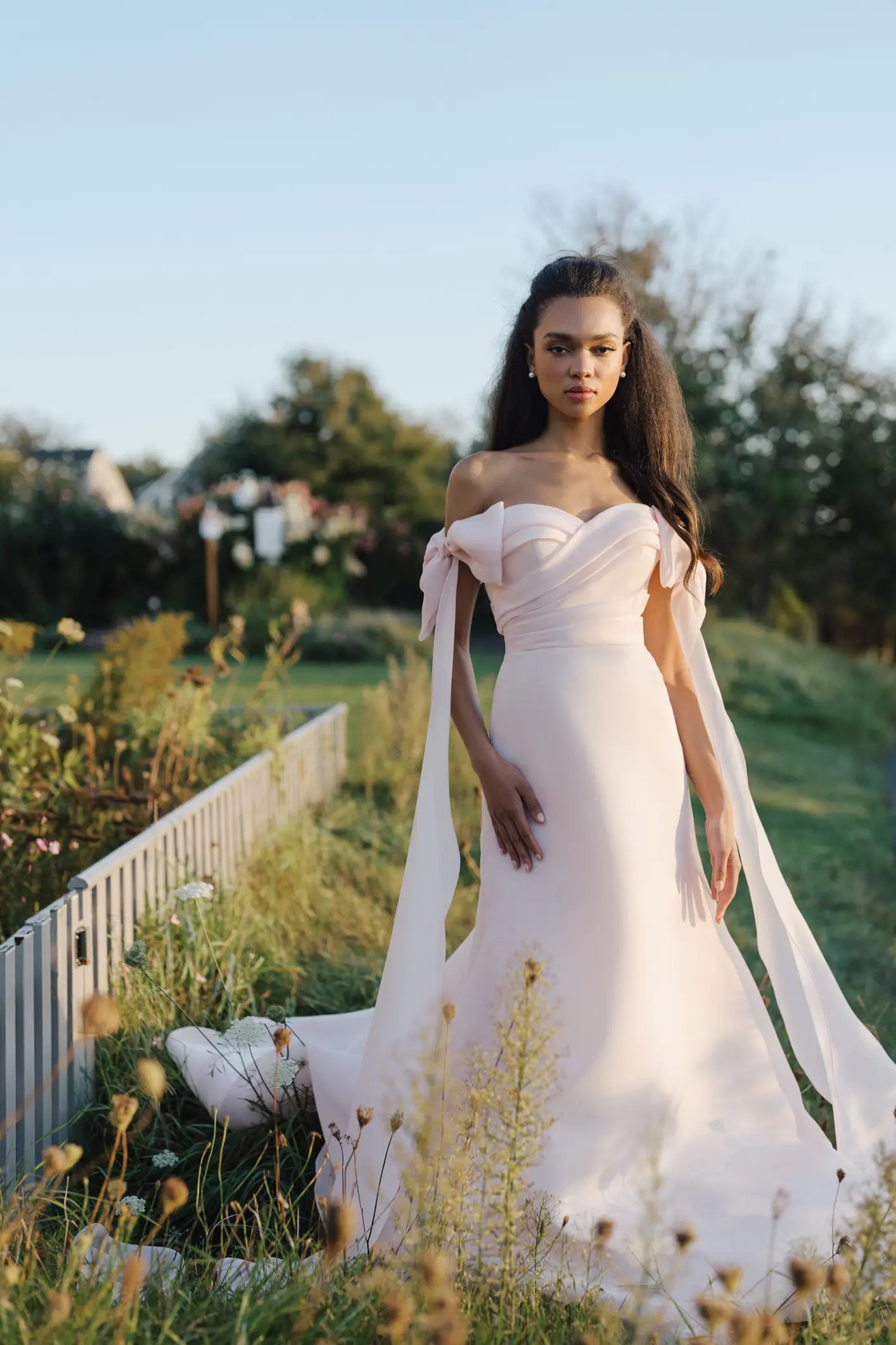 Pink blush wedding dress by Anne Barge Blue Willow style Macy with off the shoulder bows and criss cross pleated bodice, fit to flare skirt